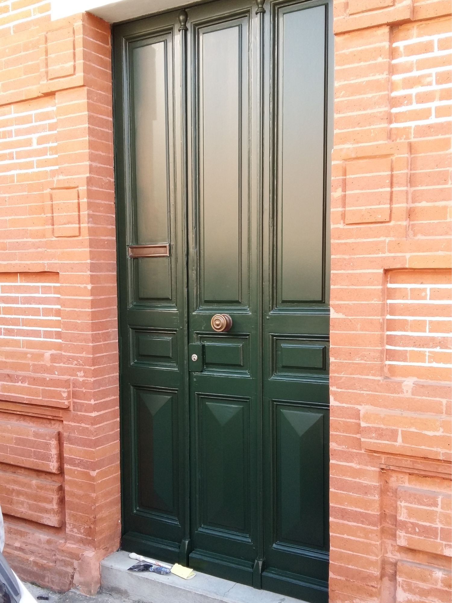 Porte d’entrée repeinte, dans une façade de brique